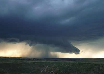 Esta foto de una <a  href="/earth/Atmosphere/clouds/cumulonimbus.html&edu=high&lang=sp&dev=">nube cumulonimbus</a> fue tomada en las <a href="/earth/grassland_eco.html&edu=high&lang=sp&dev=">praderas</a> del este de Wyoming. Note la <a  href="/earth/Atmosphere/precipitation/rain.html&edu=high&lang=sp&dev=">lluvia</a> y <a  href="/earth/Atmosphere/precipitation/hail.html&edu=high&lang=sp&dev=">granizo</a> cayendo de esta nube! Las nubes cumulonimbus se forman durante <a  href="/earth/Atmosphere/tstorm.html&edu=high&lang=sp&dev=">tormentas</a>, cuando aire hmedo y muy caliente se eleva hasta aire fro. A medida que este aire hmedo se eleva, el vapor de agua se <a href="/earth/Water/condensation.html&edu=high&lang=sp&dev=">condensa</a>, y formas enormes nubes <a href="/earth/Atmosphere/clouds/cumulonimbus.html&edu=high&lang=sp&dev=">cumulonimbus</a>.<p><small><em>    Fotografa cortesa de <a href="http://www.inclouds.com/" class=outlink>Gregory Thompson</a></em></small></p>